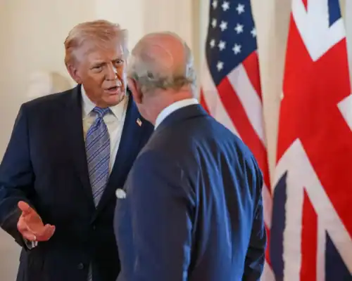 Donald Trump and Boris Johnson in discussion with UK and US flags behind them.